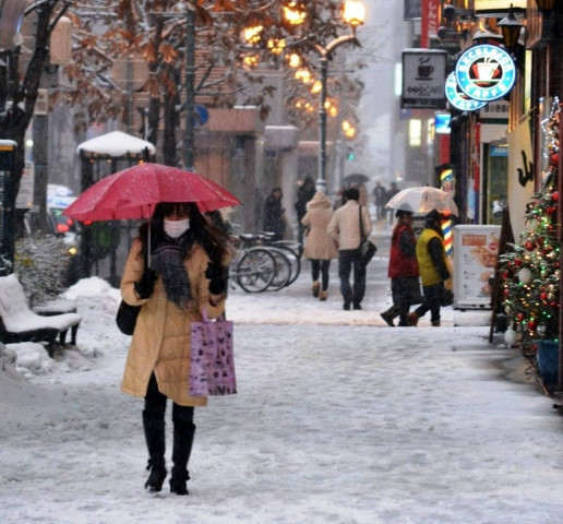 this photo taken on november 27 2012 shows pedestrians walking down a snow covered street in sapporo in japan 039 s northern island of hokkaido photo afp