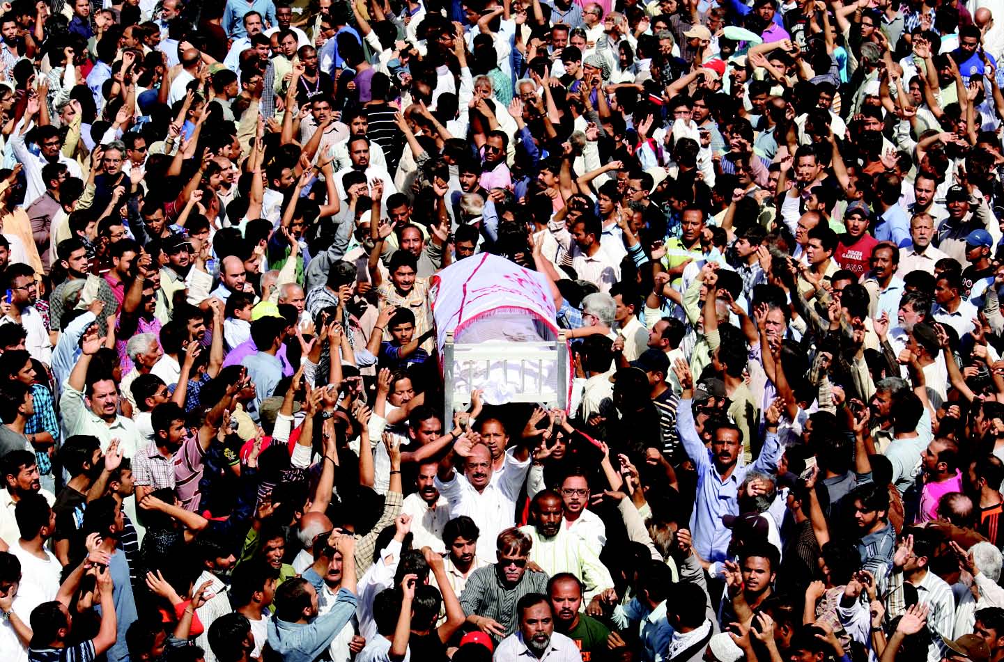 mourners at sharae pakistan prepare to take a body to wadi e hussain graveyard