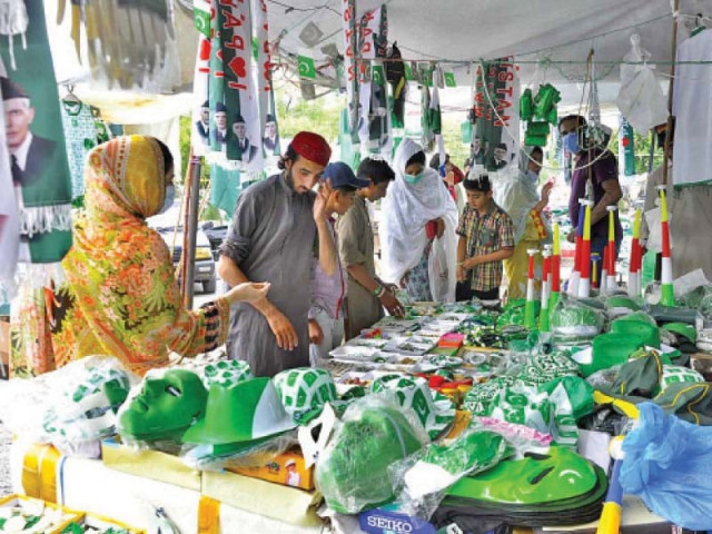 people buy flags badges and other patriotic merchandise from a roadside stall in islamabad to celebrate independence day photo app people buy flags badges and other patriotic merchandise from a roadside stall in islamabad to celebrate independence day photo app