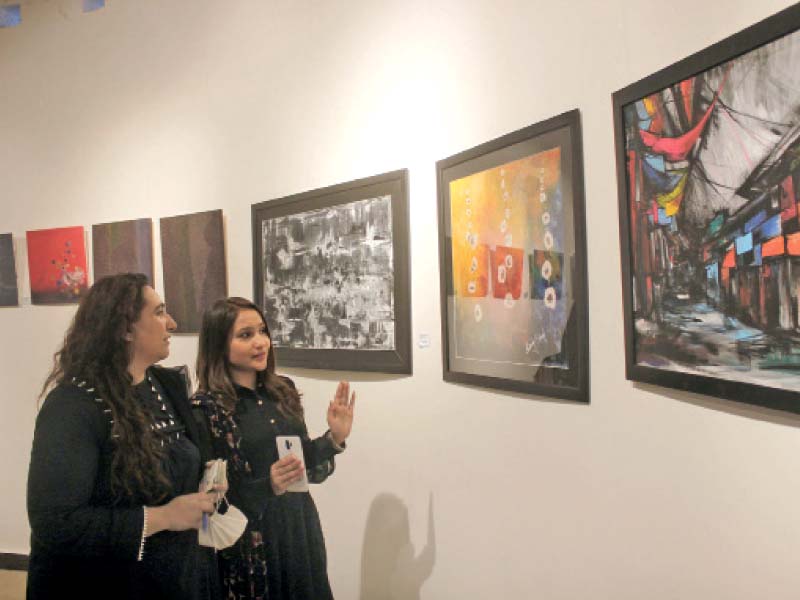 women watch artwork on display at the bexon exhibition depicting pakistani cultural heritage held at the aqs arts and craft village photo online
