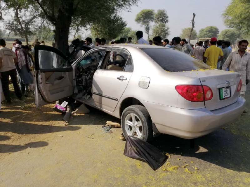 people gather around the car after it crashed into the tree photo express