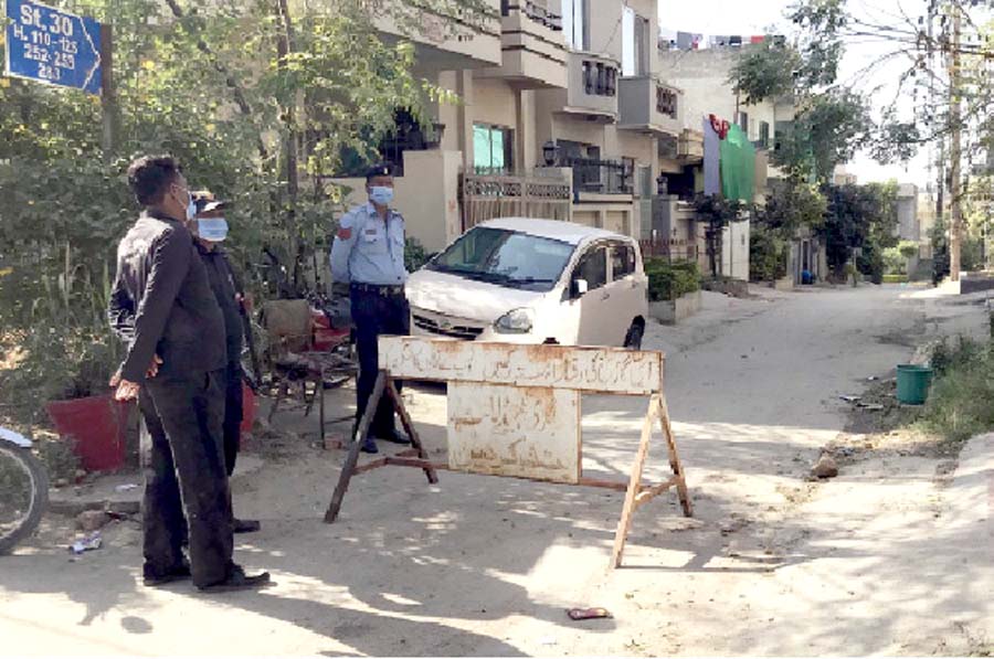 policemen guard a street sealed under a smart lockdown in pakistan colony after some residents tested positive for covid 19 photo inp