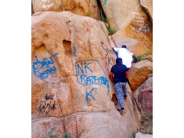 activists try to clean up stubborn graffiti left behind by tourists the walls of the karoonjhar mountains in tharparkar photo express activists try to clean up stubborn graffiti left behind by tourists the walls of the karoonjhar mountains in tharparkar photo express