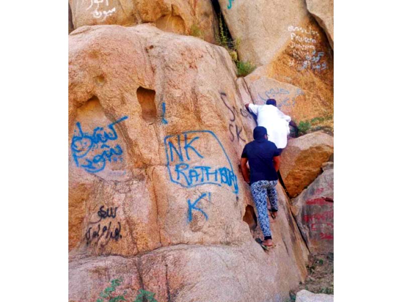 activists try to clean up stubborn graffiti left behind by tourists the walls of the karoonjhar mountains in tharparkar photo express