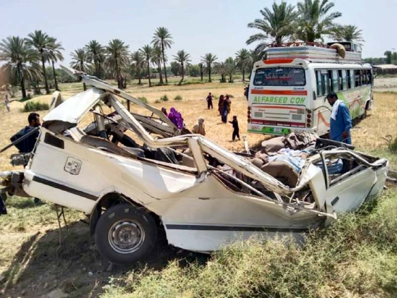 people look at the van damaged in collision with the bus which left 12 people dead on old national highway in mirpurkhas on wednesday photo nni