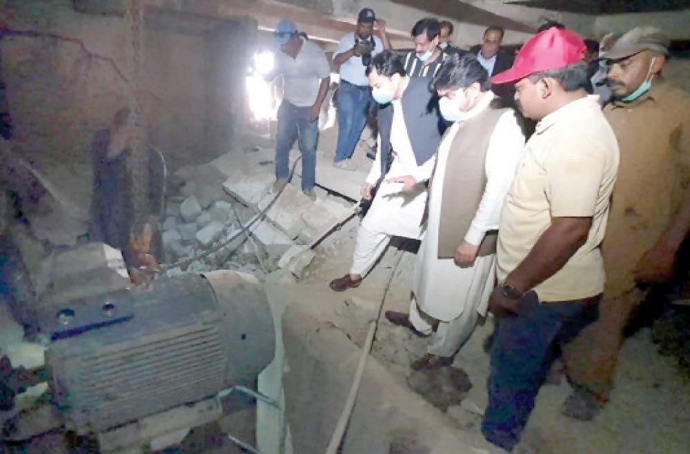 sindh local government minister nasir hussain shah and officers of kwsb look at the water pump installed on an illegal connection under a bridge in the golimar area of karachi photo express