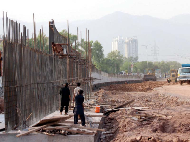 workers build upon the foundation laid for the flyover to expedite the process photo express