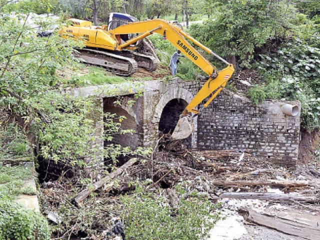 capital development authority workers clear out a nullah in sector g 8 in the aftermath of heavy rainfall in the federal capi tal photo app