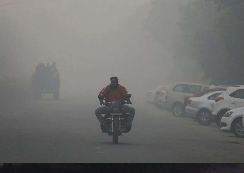 a man rides a motorbike along a road shrouded in smog in noida india november 5 2021 reuters