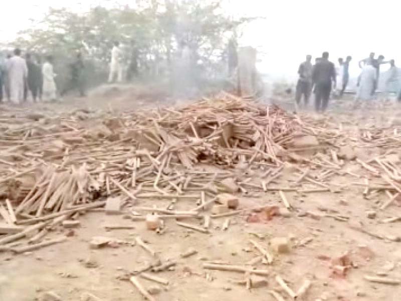 people gather near the debris of the factory destroyed in the blast photo express