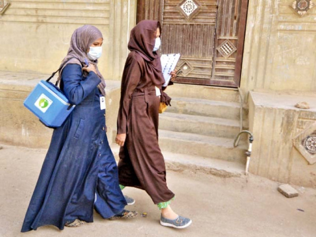 polio vaccinators carrying bag of vaccines and documents to collect data walk through a neighbourhood in karachi at the start of a nationwide inoculation drive photo jalal qureshi express polio vaccinators carrying bag of vaccines and documents to collect data walk through a neighbourhood in karachi at the start of a nationwide inoculation drive photo jalal qureshi express