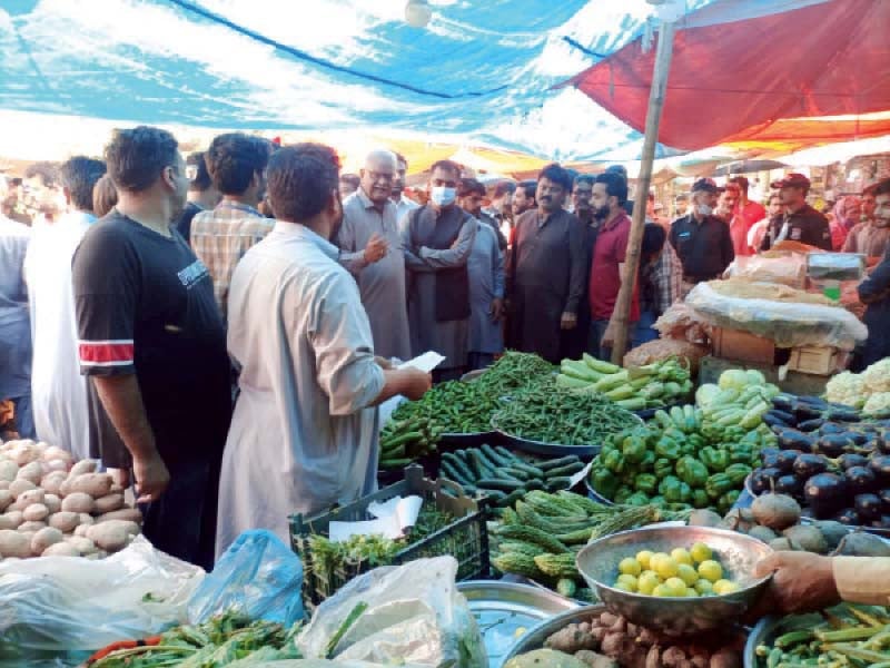 officials check the rates of vegetable on sale at empress market in karachi on tuesday photo express