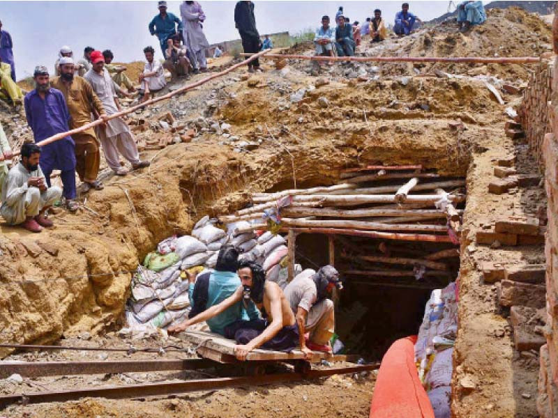 miners enter the coalmine near jhampir on thursday to retrieve bodies of their colleagues who drowned when the mine got flooded due to heavy rain on wednesday photo app