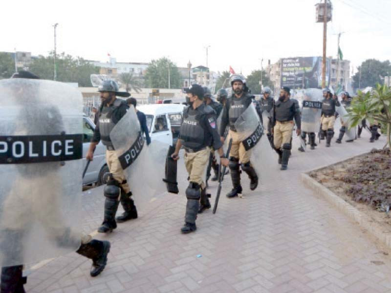 police jawans stand alert during the march of pti supporters from numaish roundabout to tibbet centre photo jalal qureshi express file