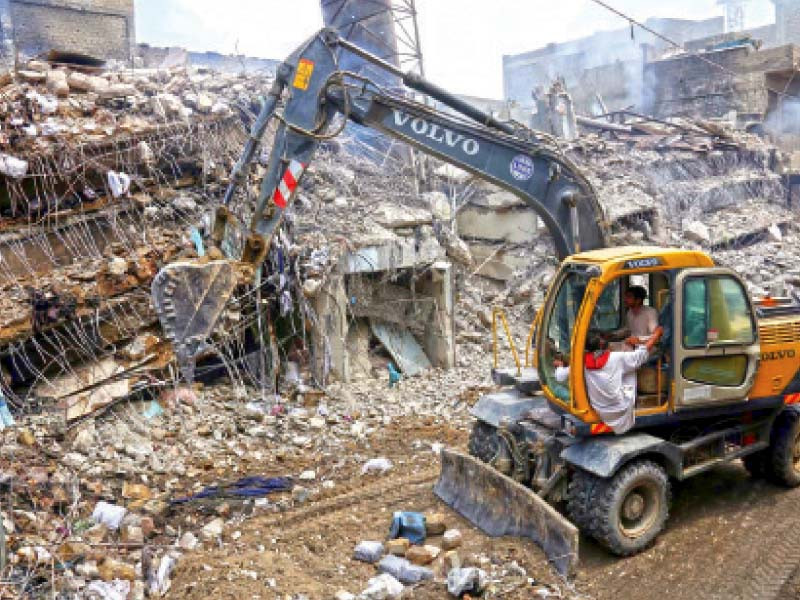 heavy machineries remove rubbles of the factory that collapsed on thursday morning killing four firefighters and injuring 13 others including 11 firemen in north karachi industrial area photo jalal qureshi express