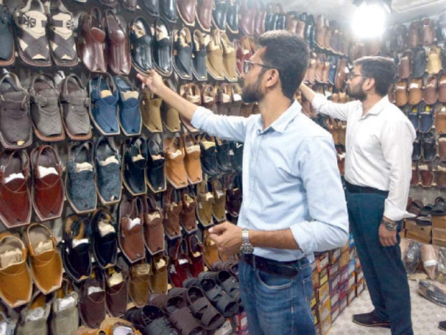 men select handmade peshawari chappals at a shop in a karachi neighbourhood photo express men select handmade peshawari chappals at a shop in a karachi neighbourhood photo express