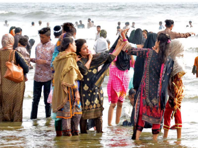 people enjoy swings at amusement parks and waves on sea view beach during the eid holidays photos jalal qureshi express