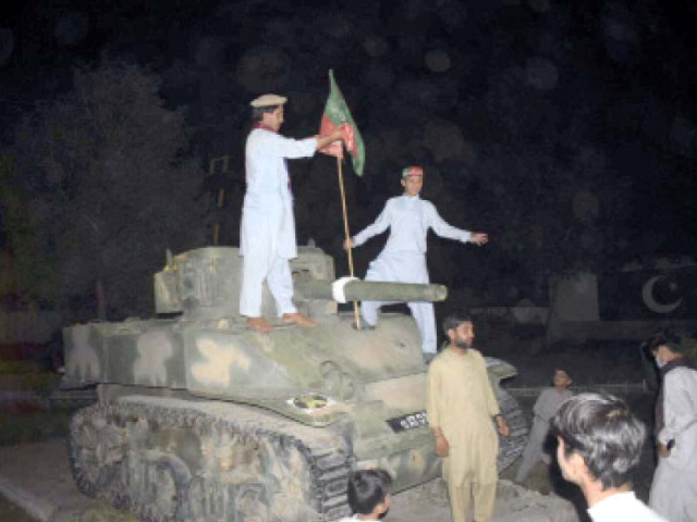 pti supporters storm bannu cantonment and hoist a flag on a tank displayed there photo express pti supporters storm bannu cantonment and hoist a flag on a tank displayed there photo express