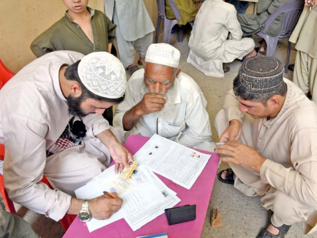 a volunteer helps afghan people fill forms for repatriation to afghanistan at a unhcr office in karachi on wednesday photo online a volunteer helps afghan people fill forms for repatriation to afghanistan at a unhcr office in karachi on wednesday photo online