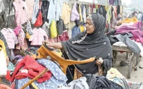 a woman selects used warm clothes from a stall alongside a road in larkana on friday photo app