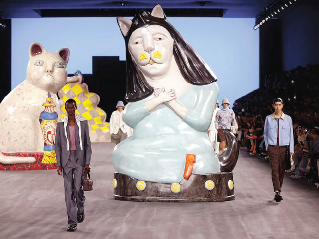 models marched past ceramic felines in tailored trousers and bermuda length shorts photo file models marched past ceramic felines in tailored trousers and bermuda length shorts photo file