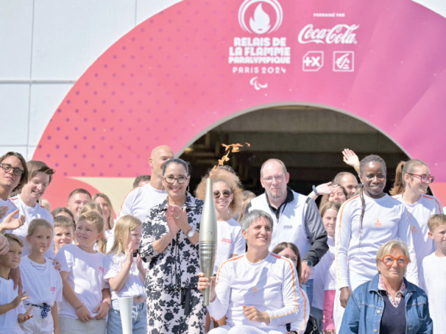 former french wheelchair fencer emmanuelle assmann holds the paris paralympics torch as it arrives in france through the channel tunnel after being lit in england photo afp