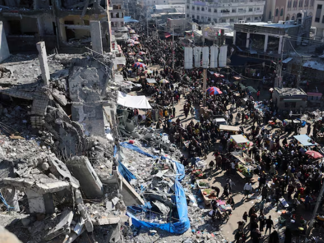 Palestinians shop in an open-air market among the ruins of houses and buildings destroyed in Israeli strikes during the conflict, amid a temporary truce between Hamas and Israel, in Nuseirat refugee camp in the central Gaza Strip November 30, 2023. REUTERS