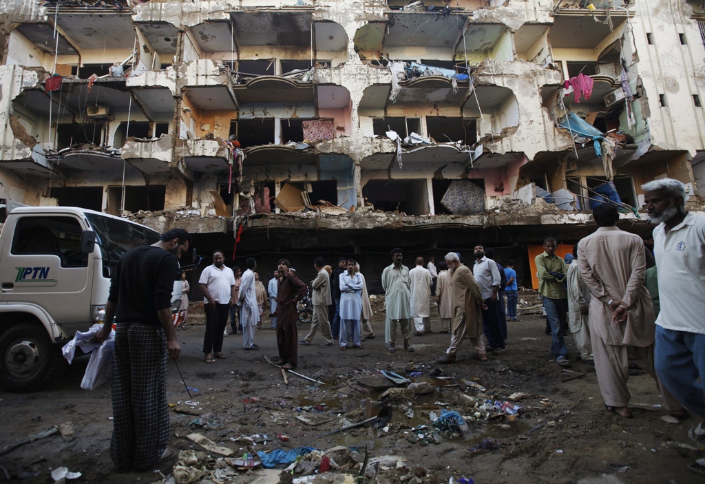 residents gather in front of a damaged building after a bomb blast in a residential area in karachi photo reuters