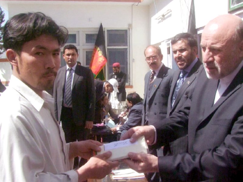 afghan ambassador to pakistan mohammad omer dawoodzai hands over a cheque to a family member of hazara town blast victim photo inp