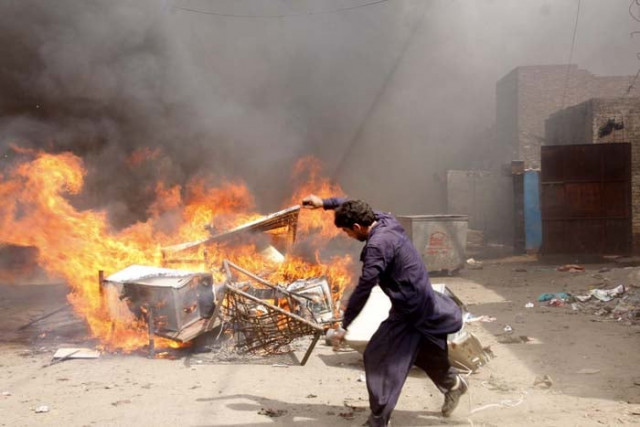 a protester burns belongings from christian houses in lahore on saturday photo abid nawaz express a protester burns belongings from christian houses in lahore on saturday photo abid nawaz express