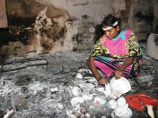 a woman rummages through broken house ware in badami bagh photo shafiq malik express a woman rummages through broken house ware in badami bagh photo shafiq malik express