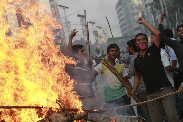 activists of jamaat e islami shout slogans as they set fire to a rickshaw van during a clash with police in dhaka march 11 2013 photo reuters