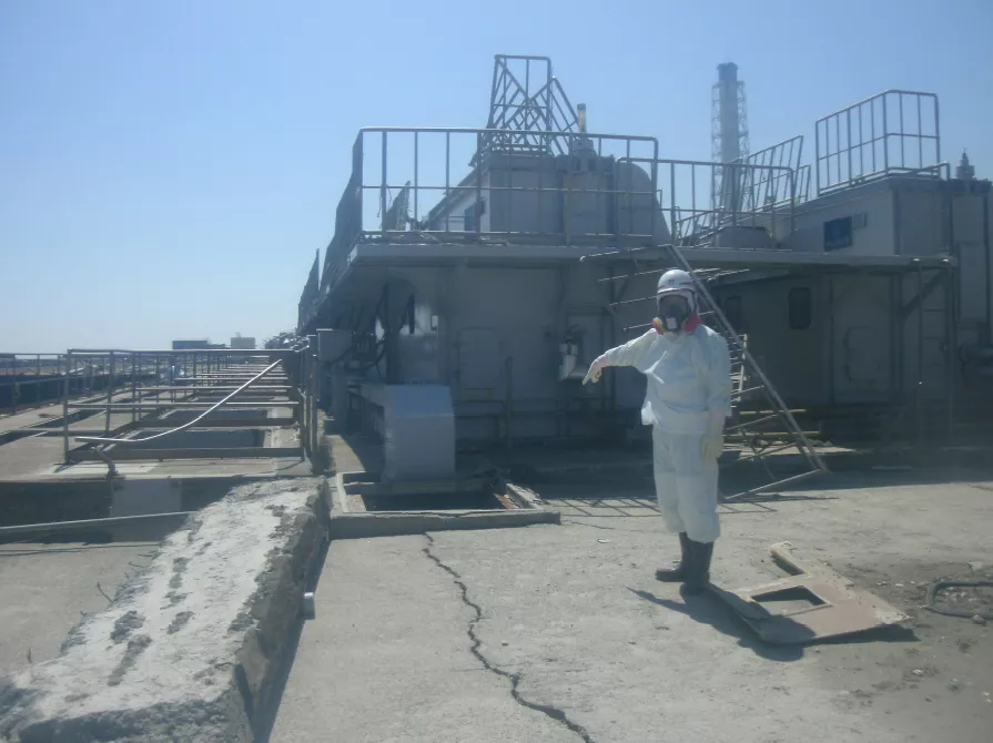 a worker wearing a protective suit points at a cracked concrete pit near its no 2 reactor of the tokyo electric power co tepco 039 s fukushima daiichi nuclear power plant april 2 2011 photo reuters