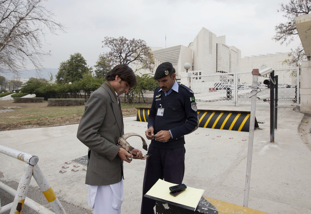 mohammed afzal who petitioned for a reinvestigation into alleged death sentences a kohistan jirga imposed is searched by a policeman as he arrives at the supreme court on february 14 2013 photo reuters