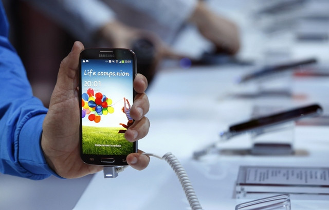 a samsung employee displays the samsung galaxy s iv for a photo march 14 2013 in new york city photo afp allison joyce