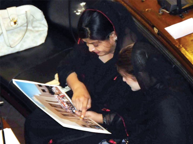 the minister for women s development tauqeer fatima bhutto looks at a picture taken at a photo session held outside the sindh assembly building last week photo express