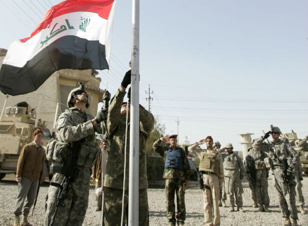 a us and an iraqi soldier raise the iraqi national flag during the handover ceremony of a military camp to the iraqi army in baghdad 039 s gazaliya district on january 1 2009 photo reuters