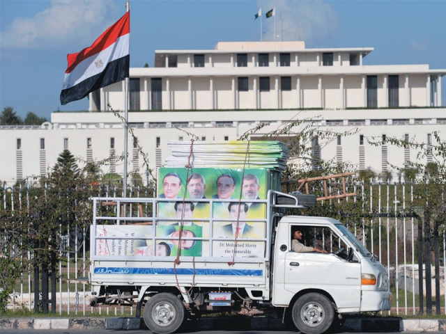 an egyptian flag flutters as a driver parks a mini truck carrying welcoming banners in front of the presidency on sunday photo afp an egyptian flag flutters as a driver parks a mini truck carrying welcoming banners in front of the presidency on sunday photo afp