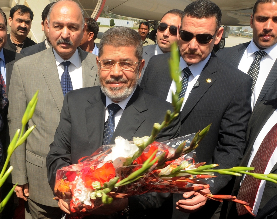 in this handout photograph released by pakistan 039 s press information department pid on march 18 2013 egyptian president mohamed morsi c receives flowers upon his arrival at the chaklala military airbase in rawalpindi photo afp