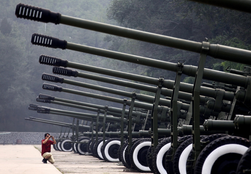 a visitor to the china aviation museum located on the outskirts of beijing takes a photograph of a row of old anti aircraft guns on display in this august 17 2010 file photo photo reuters