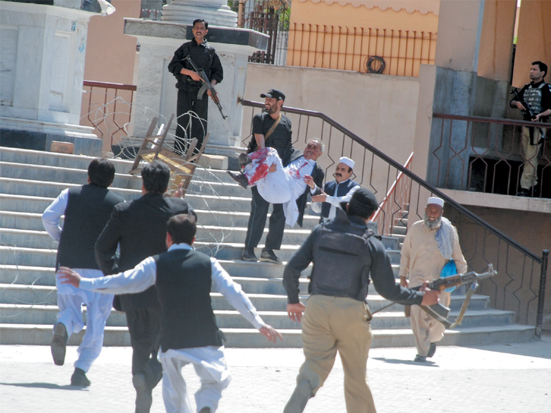 police and volunteers rush to shift the injured to hospital following the suicide blast at the judicial complex photo muhammad iqbal express