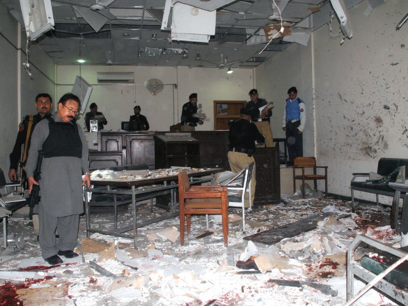 policemen examine a damaged courtroom following the suicide attack photo muhammad iqbal