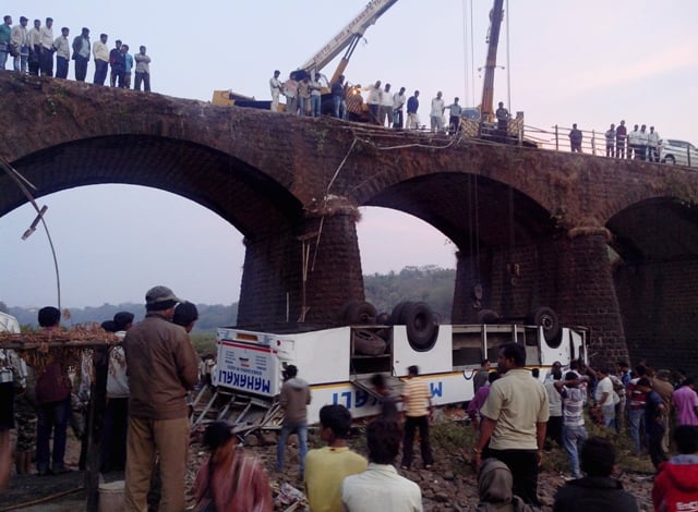 rescuers and bystanders look at the wreckage of a passenger bus after it fell from a bridge in ratnagiri district in india photo reuters stringer