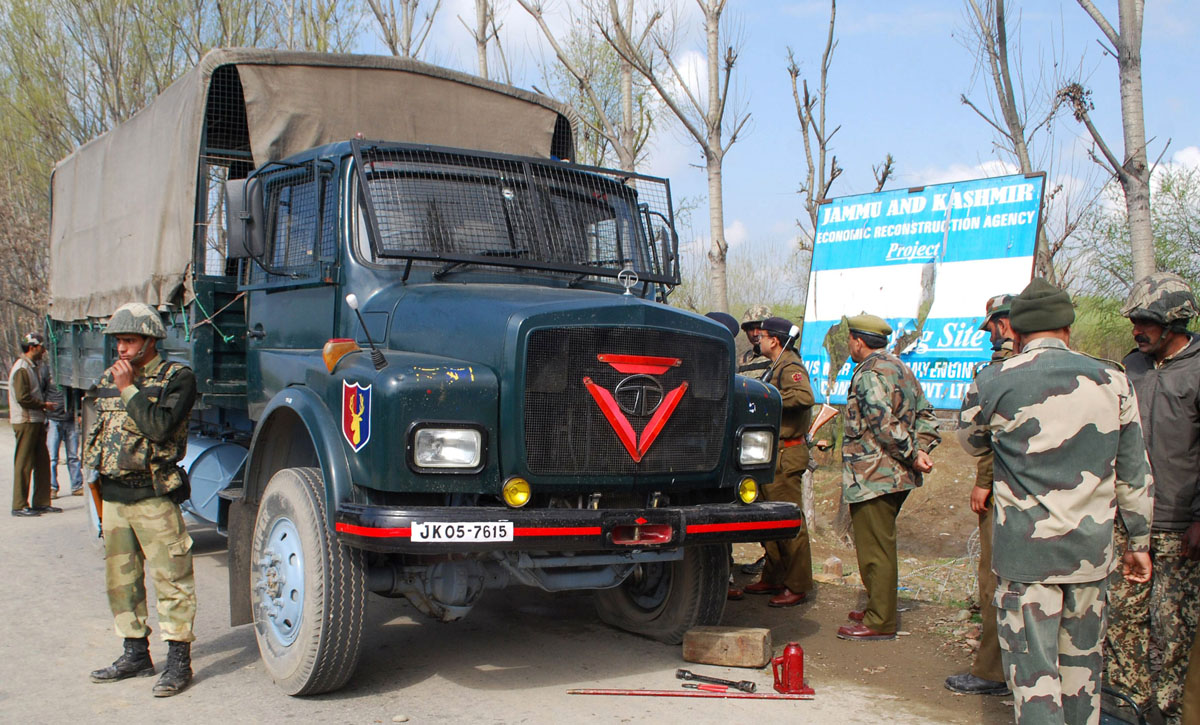 indian border security force bsf soldiers and police stand near a damaged vehicle at the site of a shootout on the outskirts of srinagar on march 21 2013 photo afp