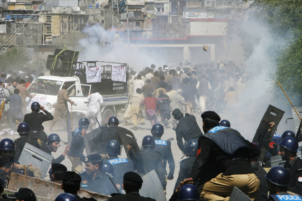 riot police officers run towards protesters during a demonstration against power outage in muzffarabad on march 21 2013 photo reuters