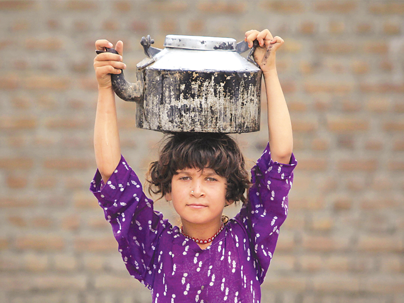 a girl displaced by the 2010 heavy floods carries a pot of water which she filled from a hand pump in nowshera photo file