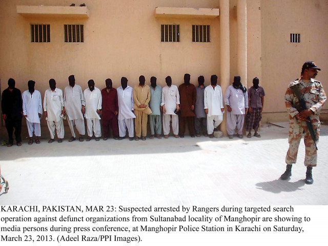 a rangers official stands near suspects arrested during an operation in sultanabad on saturday photo ppi a rangers official stands near suspects arrested during an operation in sultanabad on saturday photo ppi