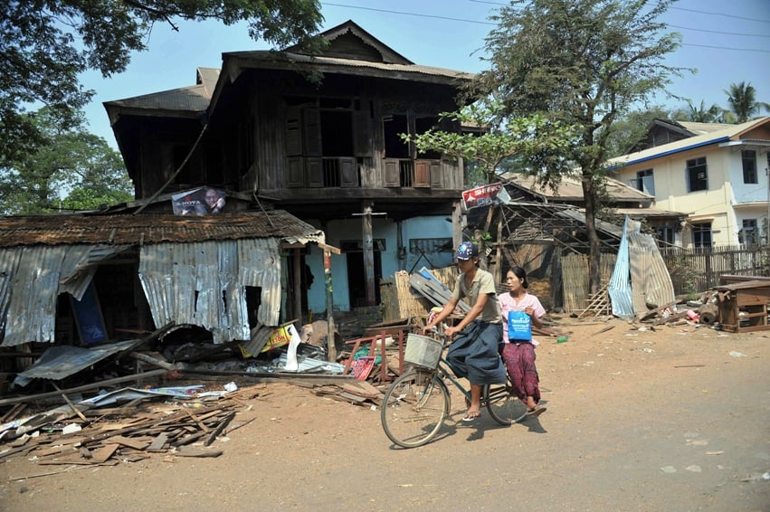 a man rides a bicycle past a ransacked house after sectarian violence spread through central myanmar in zeegone bago division on march 28 2013 photo afp