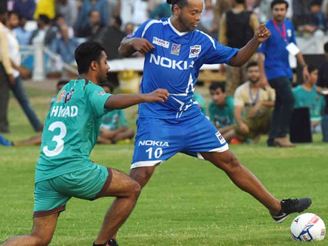 former player for fc barcelona brazilian ronaldinho r vies with pakistani football players during a friendly match on july 9 2017 in lahore eight of football 039 s biggest stars including brazilian hero ronaldinho will play two exhibition matches in pakistan this weekend in hopes of attracting more players from the cricket mad country photo afp arif ali
