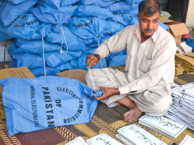 an ecp worker packs documents for polling stations in lahore photo afp